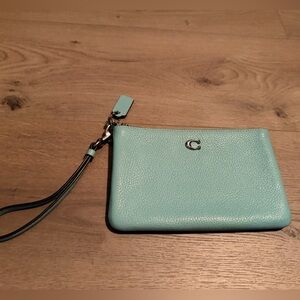 Turquoise colored coach wristlet.
